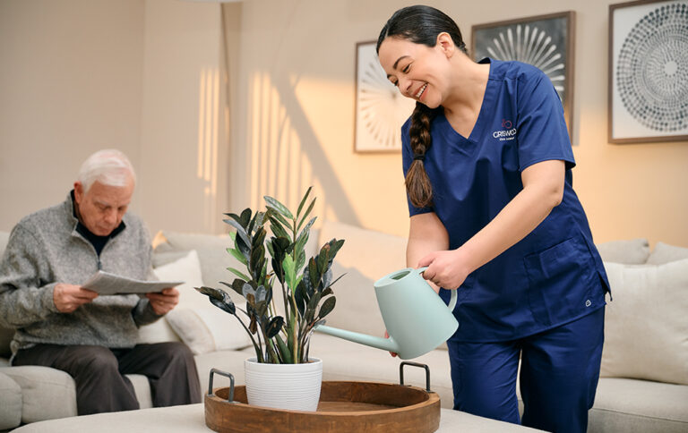 Caregiver watering plant for senior