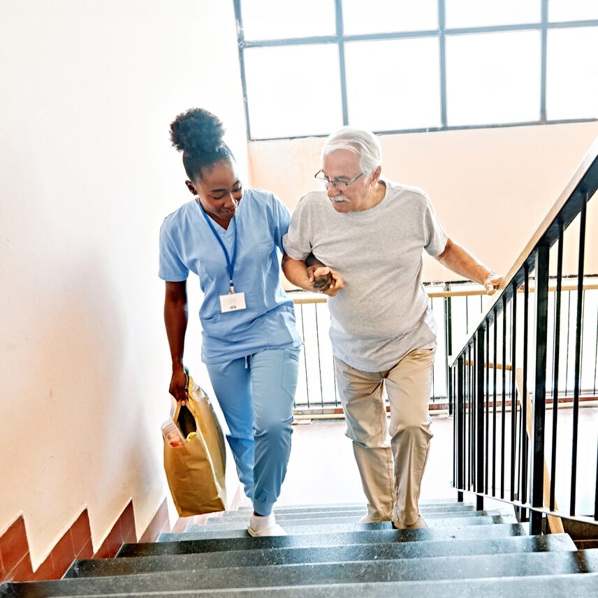 caregiver helping senior up stairs