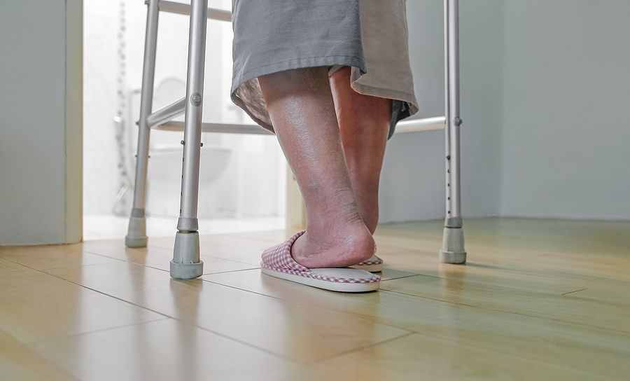 A person using a walker is wearing slippers