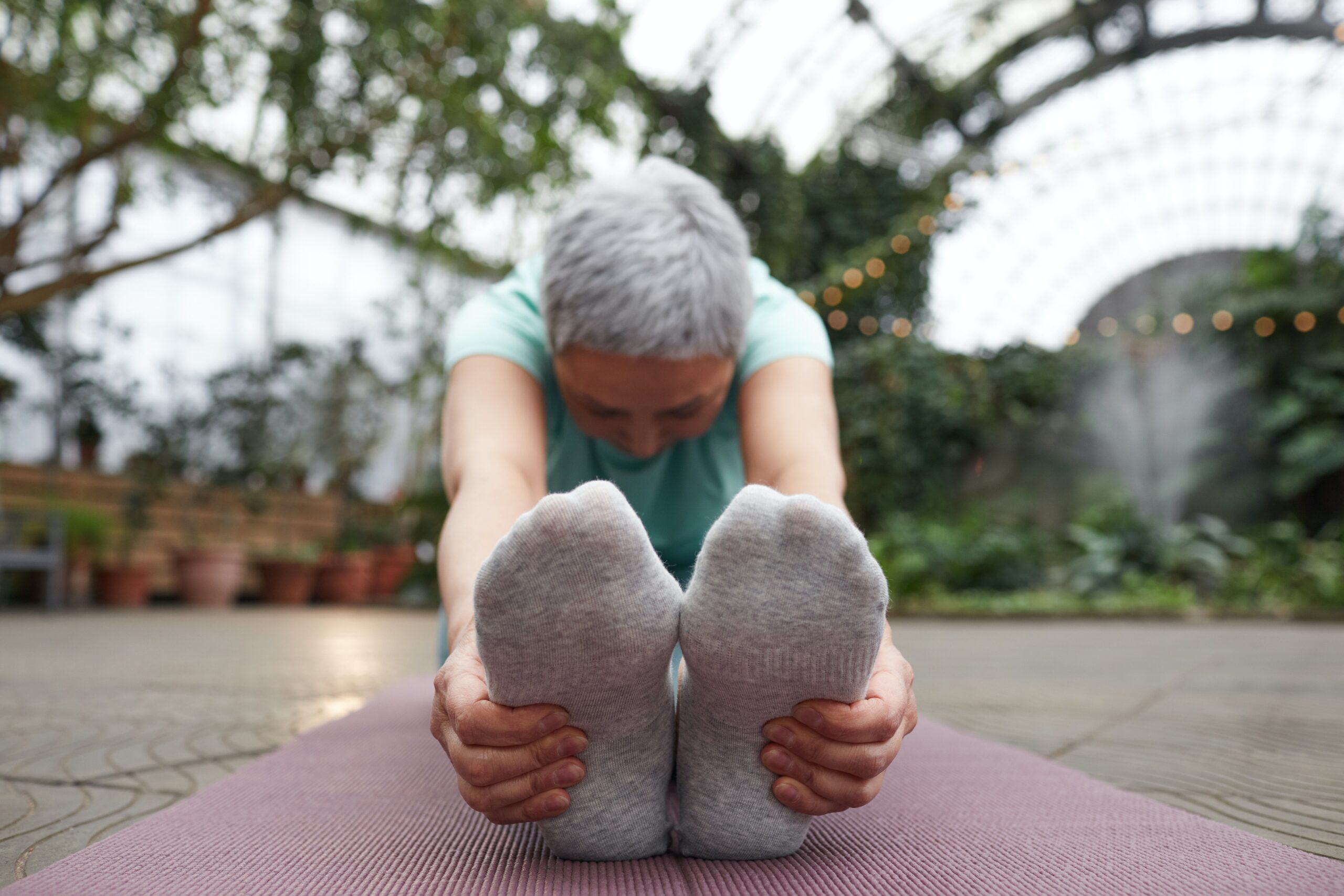 A person stretches forward, touching their feet