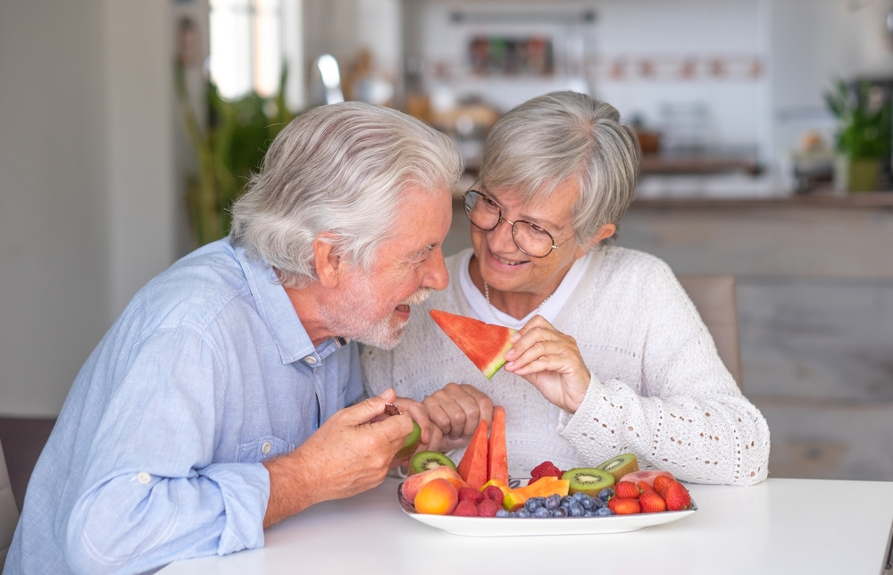 Elderly couple enjoying a plate of fruit