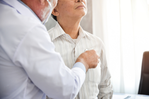 A doctor uses a stethoscope to listen to a patient's chest during a medical exam