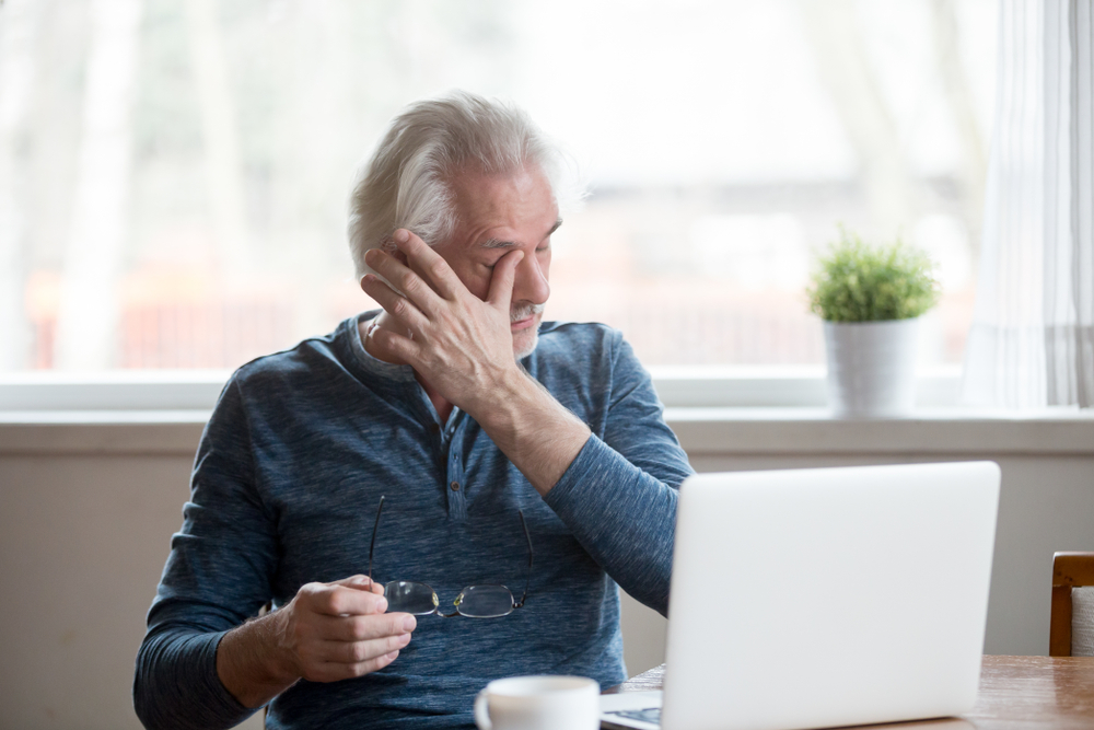 An elderly man sitting at a table