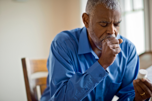 An older man coughing