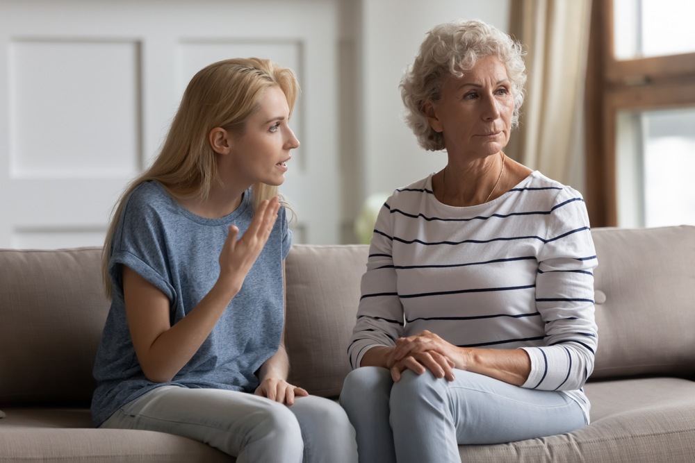 A young woman appears to be talking to an older woman who looks away