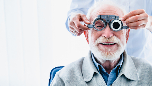 An older man undergoing an eye examination with a phoropter