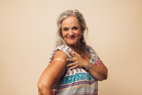 A woman showing a bandage on her upper arm