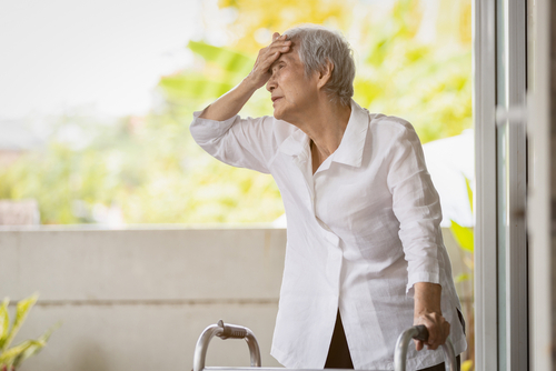 An elderly person uses a walker