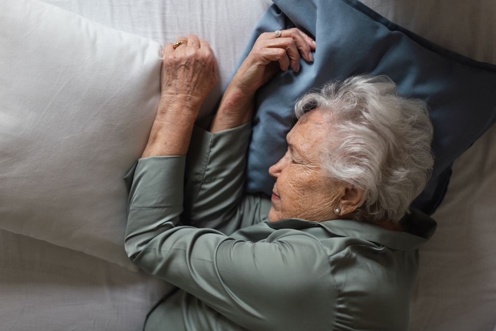 An elderly person sleeps on their side