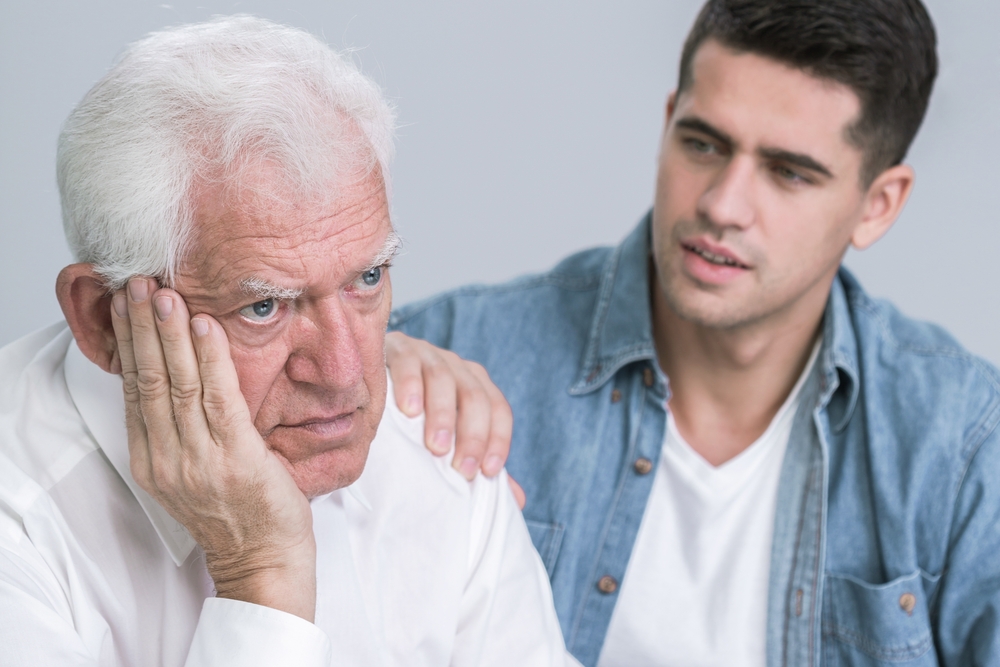 An elderly man looks distressed