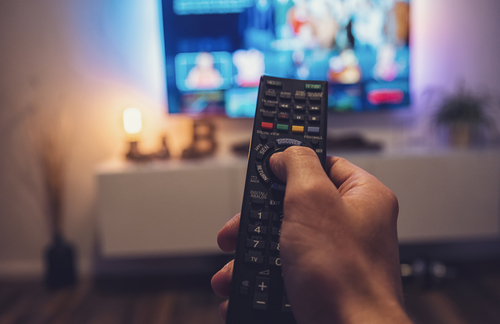 Close-up of a hand holding a TV remote