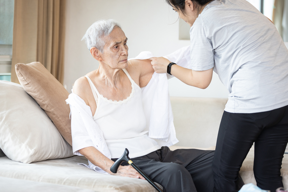 Caregiver helps patient dress