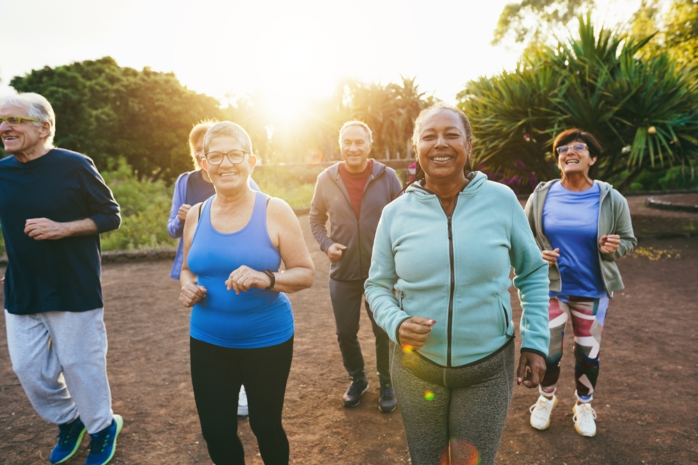 A group of adults in athletic wear jog outdoors