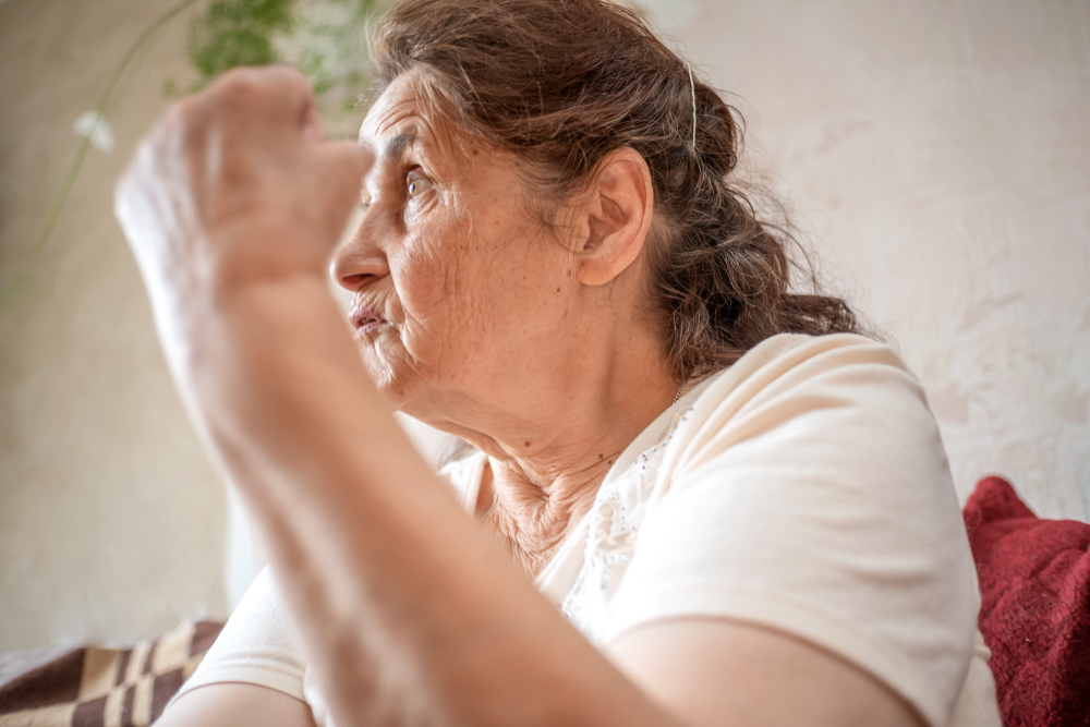 Elderly woman gestures with her arm raised