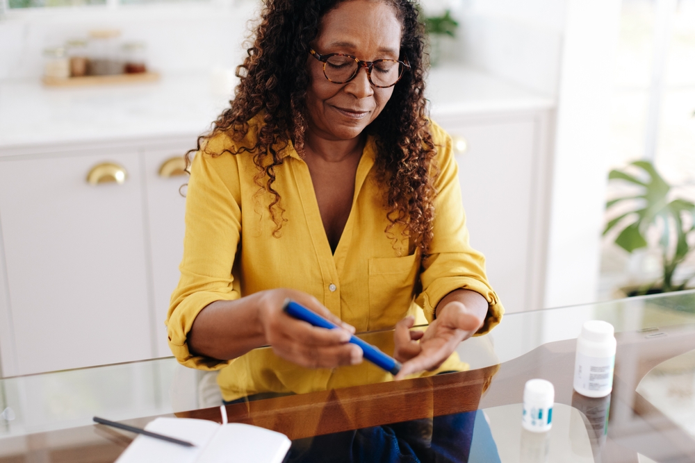 checking her blood sugar level with a glucose meter.