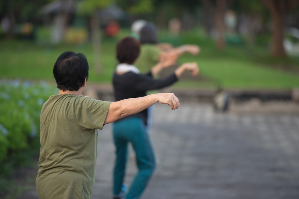 People practice Tai Chi in a park